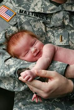 a soldier holding a baby in his arms