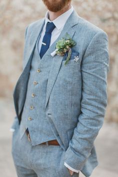 a man in a suit and tie is looking at the camera with his hand on his hip