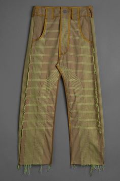 an old pair of pants with fringes on the bottom and side, sitting on a gray surface