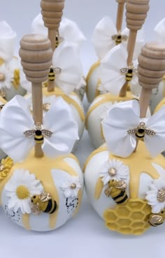 some white and yellow candy apples with bees on them are sitting next to each other