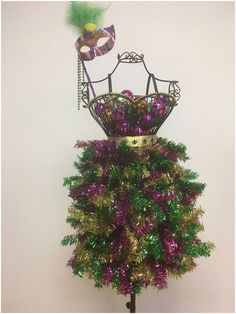 a mannequin made out of tinsel and other items on a stand in front of a white wall