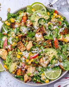 a salad with chicken, avocado, corn and dressing