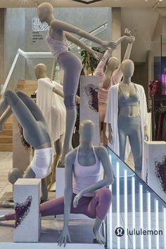 mannequins are standing in front of a display window