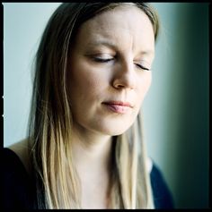 a woman with her eyes closed looking down