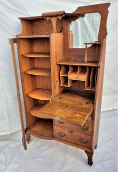 an old wooden armoire with drawers and mirror