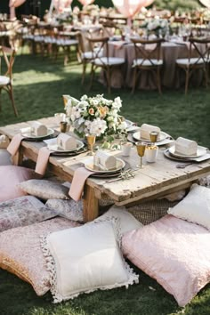 a table set up with pillows and place settings