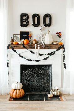 a fireplace decorated for halloween with black and white decorations