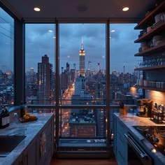 a kitchen with a view of the empire building and new york city at night from it's window