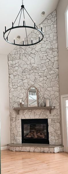 a living room with a fire place and a chandelier hanging from the ceiling