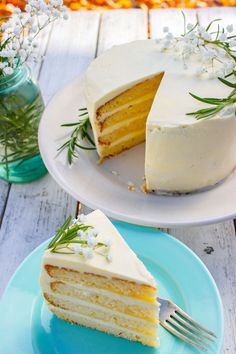 a slice of cake on a plate with a fork next to it and a jar of flowers