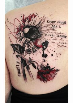 a woman's back with flowers and words tattooed on her shoulder, which reads every cloud has a silver lining