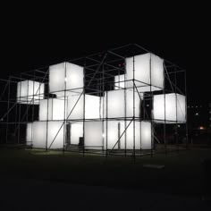 a group of white cubes sitting on top of scaffolding in the dark