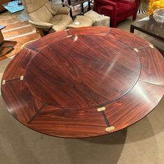 a round wooden table sitting on top of a carpeted floor