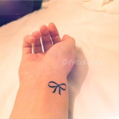 a small bow tattoo on the wrist