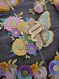 an assortment of paper flowers and butterflies on a table