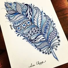 a drawing of a blue feather on white paper