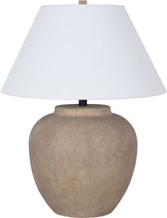 a lamp that is on top of a white table cloth next to a brown vase