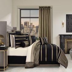 a bed with black and white striped comforters in a room next to a window