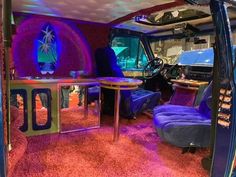 the interior of a vehicle that has been decorated with purple and blue furniture in it