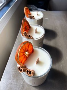 three orange slices are sitting on top of some white candles