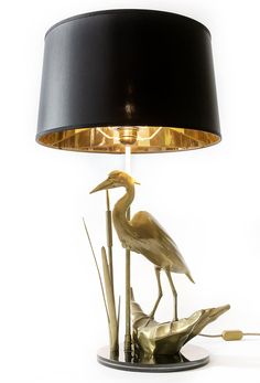 a lamp that has a bird on it and is next to some water lilies