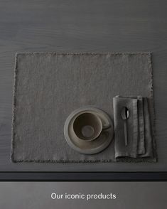 a place mat with a cup and saucer on it next to a fork and spoon