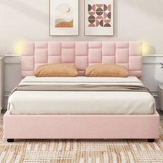 a bed with pink headboard and pillows in a white room next to two pictures on the wall