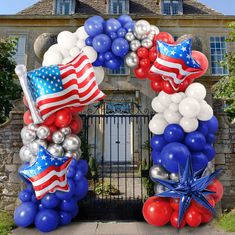 an arch decorated with balloons and stars in front of a house