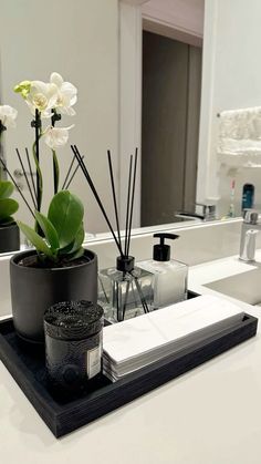 a bathroom sink with flowers and candles on it