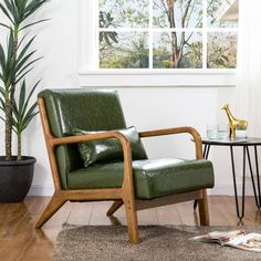 a green leather chair sitting in front of a window