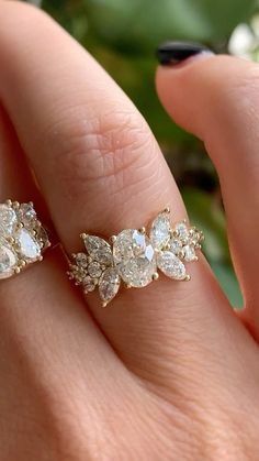 a woman's hand holding an engagement ring with three pear shaped diamonds on it