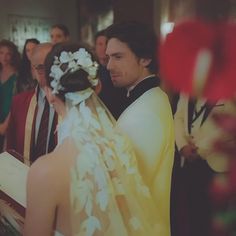 the bride and groom are looking at each other as they stand in front of their guests