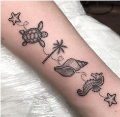 a small tattoo on the arm of a woman with sea animals and palm trees around her