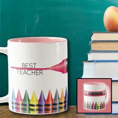 a coffee mug with crayons on it next to books and an apple in front of a chalkboard