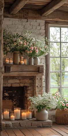 a fireplace with candles and flowers in front of it