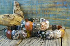 Each bead in this gorgeous Ocean Jasper bracelet is a mini-masterpiece! The colors are a unique mix of earthy tones and the patterns on each stone bead are unique. Each bracelet is truly one-of-a-kind! (7.5" x .75" wide) Ocean Jasper is a protective, multi-colored stone with spherical patters that are said to hold ancient mystic knowledge and wisdom. It has a gentle and nurturing energy. This stone can help reveal and facilitate the healing of unresolved emotions, inspiring peace and happiness. Earthy Jasper Beaded Bracelet With Natural Stones, Earthy Jasper Beaded Bracelets With Natural Stones, Earthy Beaded Bracelets With Natural Jasper Stones, Earthy Handmade Stretch Bracelet With Round Beads, Earthy Multicolor Beaded Bracelets With Natural Stones, Earthy Multicolor Beaded Bracelet With Natural Stones, Earthy Handmade Stretch Bracelet, Earthy Jasper Gemstone Bead Bracelets, Earthy Jasper Gemstone Beads Bracelet