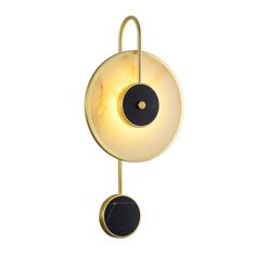 a wall light with a black and white ball hanging from it's back end