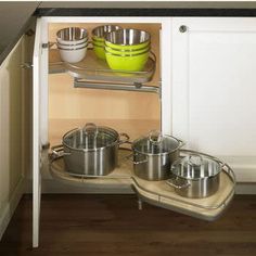 an open cabinet with pots and pans in it