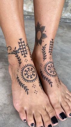 a woman's feet with tattoos on them