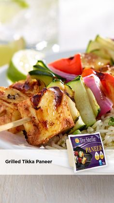 grilled tikika paneer with rice and vegetables on a white platter