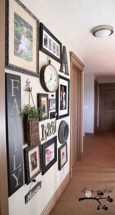 a hallway with many pictures on the wall and a clock mounted to the side of the wall