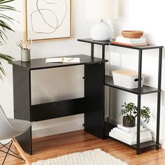 a black desk with a white rug in front of it and a potted plant next to it