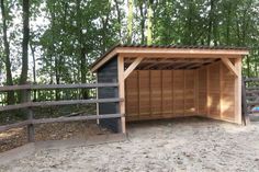 a small wooden shelter in the middle of a wooded area