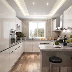 a modern kitchen with white cabinets and counter tops, along with an island in the middle