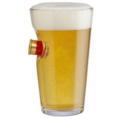 a tall glass filled with beer next to a red bottle opener on a white background