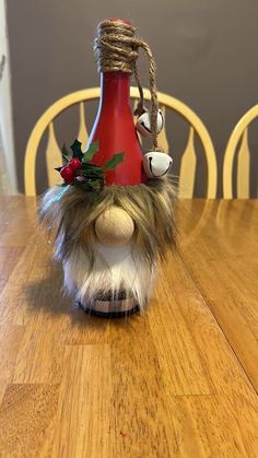 a stuffed animal with a christmas decoration on it's head sitting at a table