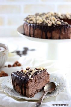 there is a piece of chocolate cake on the plate with a spoon next to it