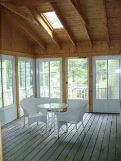 an enclosed porch with white wicker furniture and sliding glass doors