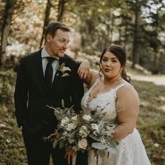 a bride and groom posing for a photo in the woods with their wedding bouquets