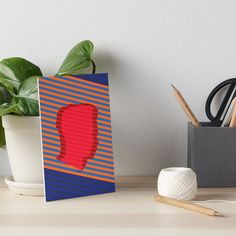 a red shoe sitting on top of a wooden table next to a potted plant